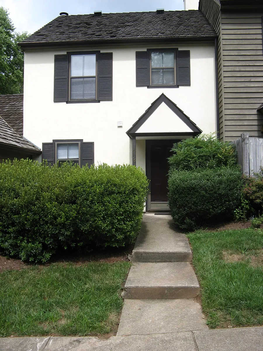 sitting patio behind tall azalea bushes to the left - 738 Exton Ct