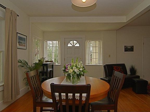 the main floor features an open dining/living room layout, original wood floors, high ceilings & mul