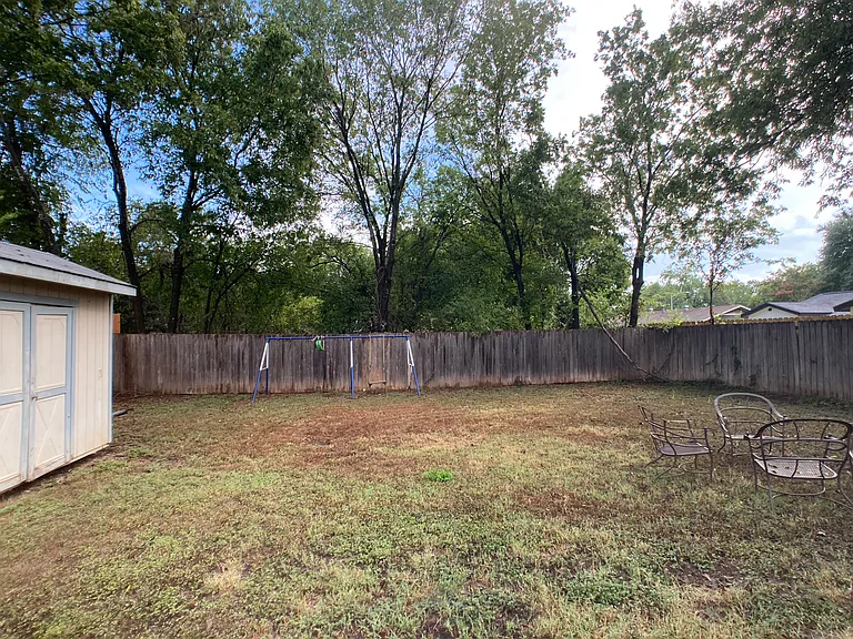 back yard, opposite view. Fully enclosed privacy fence. Swing, chairs will be removed