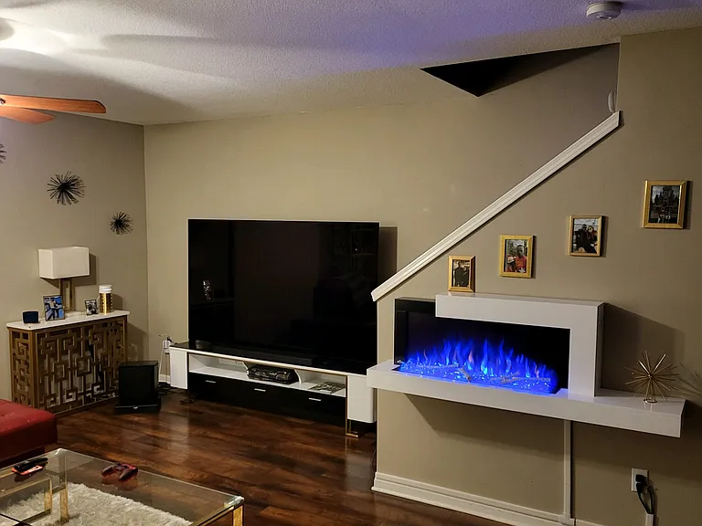 Living room with mounted electric fireplace.