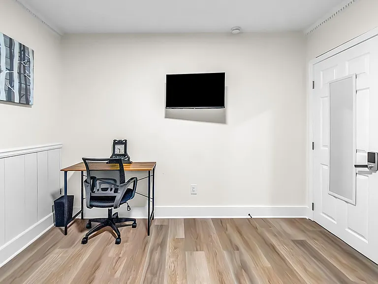 A dedicated desk area for work or study & a wall-mounted television.