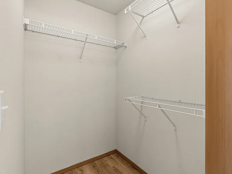 Spacious walk-in closet with built-in shelving. Spacious walk-in closet with built-in shelving.