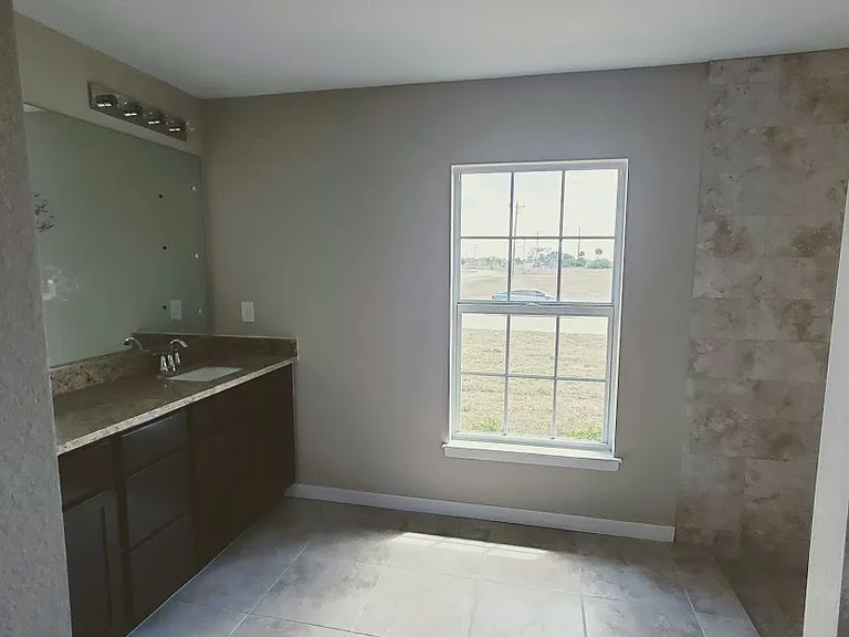 master bath with window and tiled shower