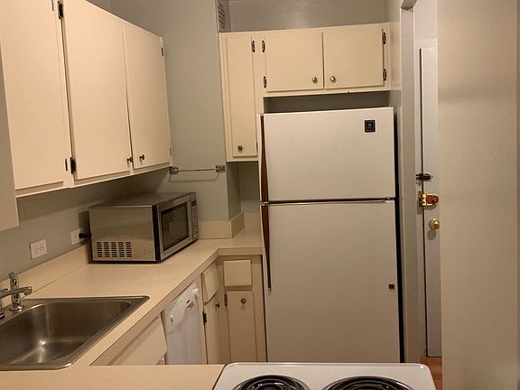White kitchen with apartment-size dishwasher.