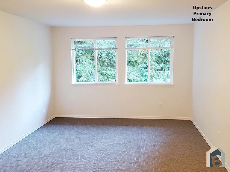 2nd floor large primary bedroom with beautiful view of mature evergreens