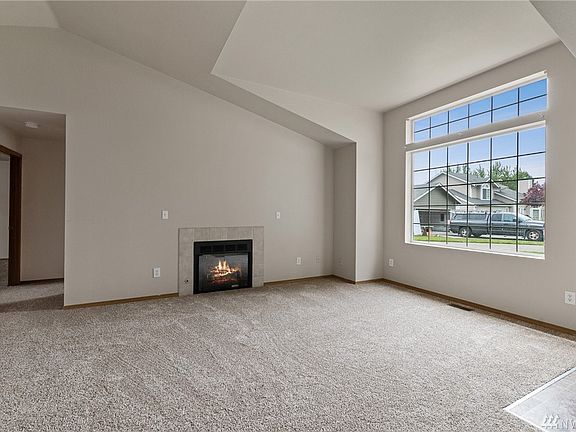 The airy living room is made cozy by gas fireplace. Plush new carpet has been installed throughout the residence. 