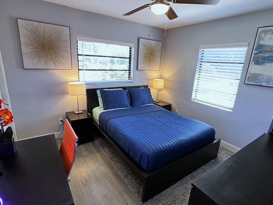 Room 2 features: Queen bed, dual night stands, table lamps, ceiling fan, mini fridge, desk, 65in TV