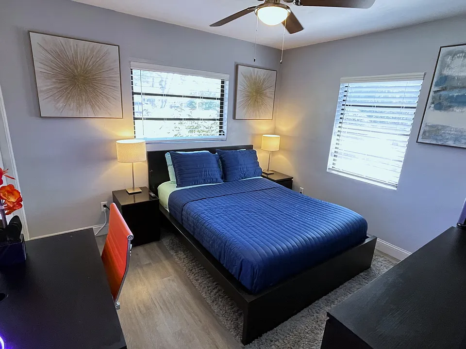 Room 2 features: Queen bed, dual night stands, table lamps, ceiling fan, mini fridge, desk, 65in TV