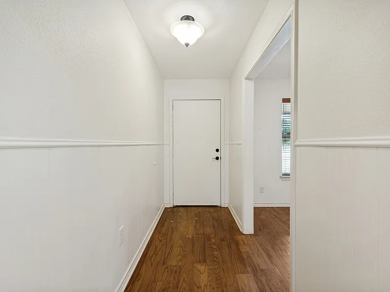 Hallway to front door and kitchenette to the right.