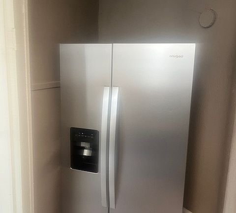 New side-by-side refrigerator with water/ice dispenser.