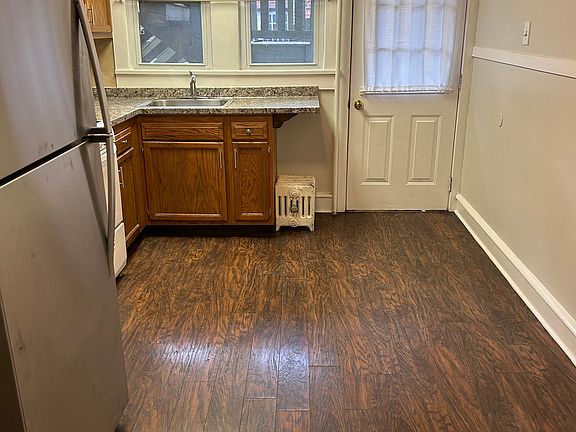 Kitchen with hardwood floors and backdoor to parking lot behind the apartment