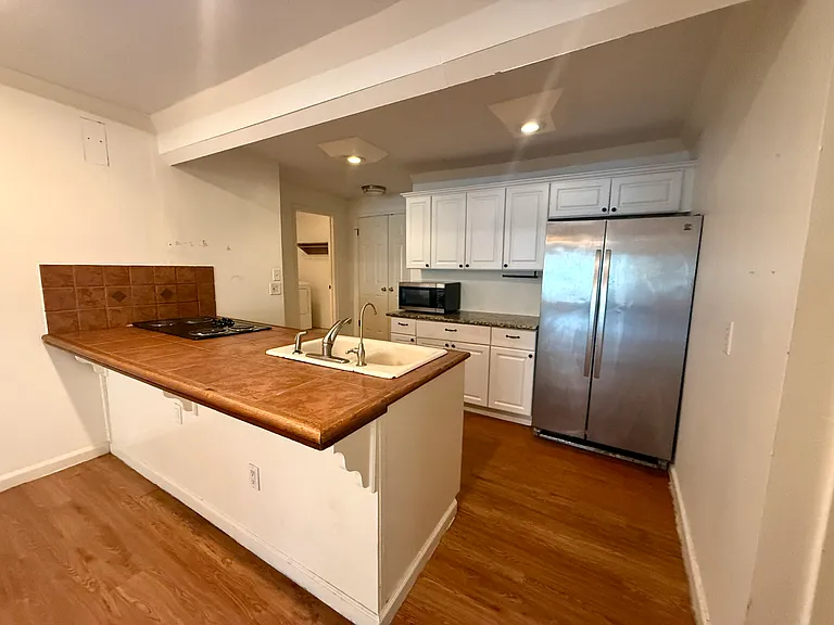 Kitchen area, which leads to a LARGE pantry that can handle small appliances, bulk items, and easy, ample shelf dividing for roommates.
Visible in the far corner of the kitchen area is door to laundry and additional storage.
Door to 3rd BR to the R.