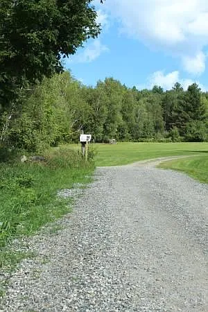 Dirt road and driveway and mailbox to house