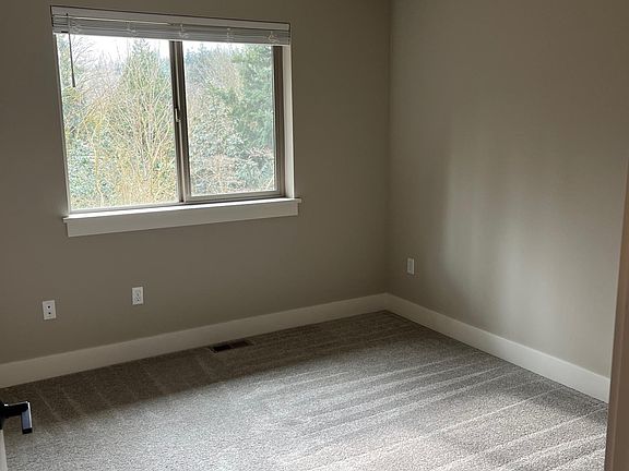 Carpeted bedroom with greenbelt views