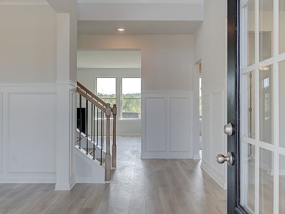 Front entry with glass panels and LVP flooring at single family home at Brighton in Locust Grove, GA