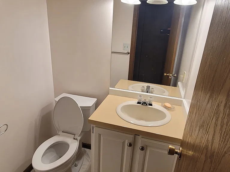 Ground level half bathroom located just down the left hallway from the kitchen.
