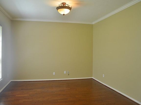 Living room  boasting wood floors, overhead lighting, can be a study.