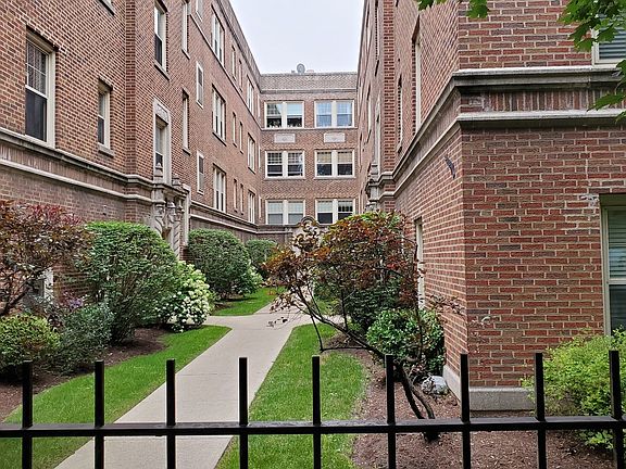 Beautifully landscaped courtyard building with wrought iron fence surround