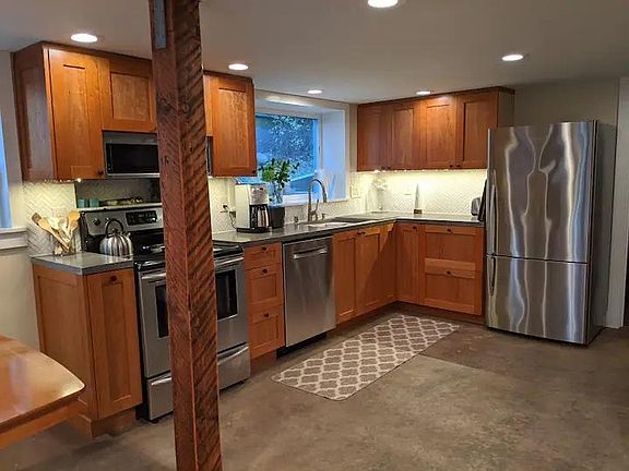 Full kitchen with fridge, stove and oven, dishwasher, microwave, and cherry cabinets.