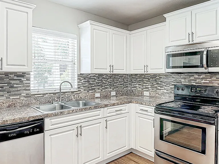 The Suite kitchen features a chic mosaic tile backsplash, offering a modern and sleek look.