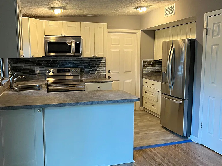 Looking into kitchen from dining room. all new appliances . counter tops.