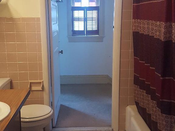 Bathroom. 2 doors- one into a bedroom and the other into the hallway. Full bath tub.