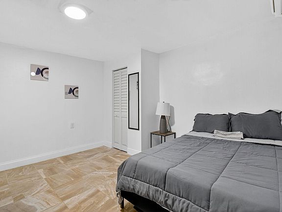 Furnished bedroom with a full-size bed, nightstand and lamp, plus a closet for everyday storage.
