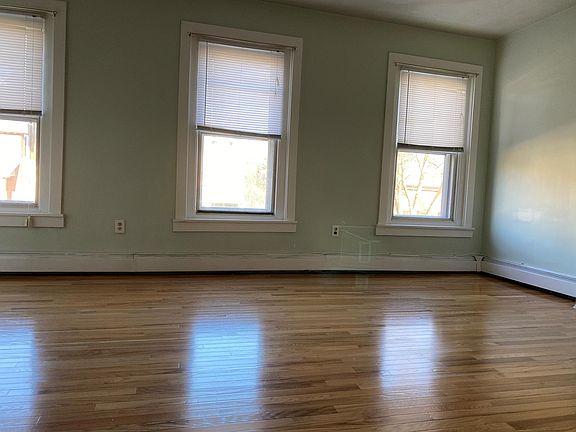 Large bedroom with three large windows, street view