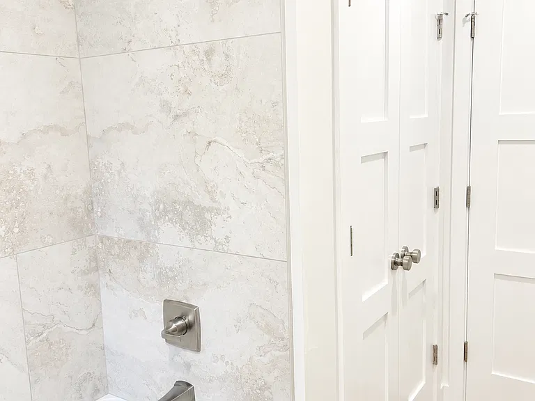 A dedicated toilet nook offers enhanced privacy while maintaining an open, spacious bathroom layout. A large linen closet provides generous storage for towels, toiletries, and everyday essentials keeping the bathroom organized and clutter-free.
