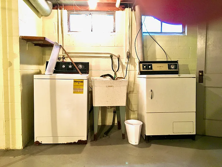 Washer, Dryer, and Laundry sink in basement.