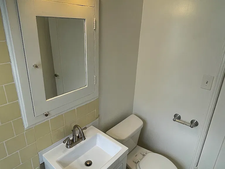 203 Bathroom has newer tile, lighting, vanity, hardware