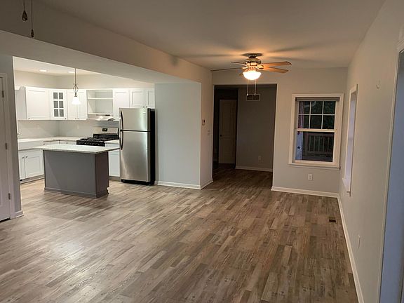 Open floor plan L shaped kitchen, dining & living room access to outdoor wood deck.