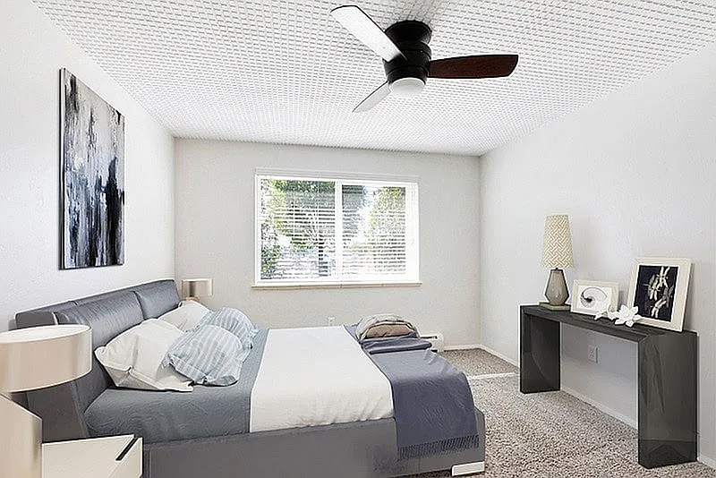 Bright bedroom with elegant decor, featuring a stylish bed, modern ceiling fan, and large window for natural light.