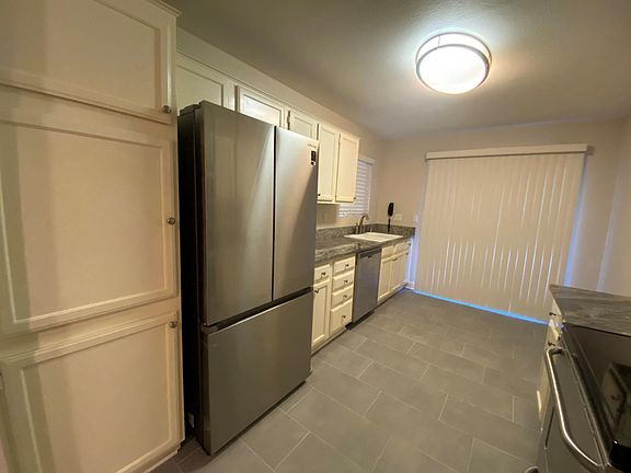 Kitchen with new flooring and new refrigerator. Includes Dishwasher and garbage disposal