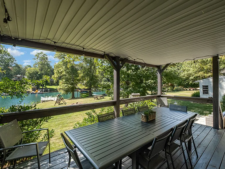 The covered deck is the perfect place to dine overlooking the lake.
