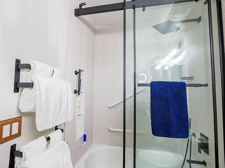 Main hall bath with tub, rain shower head, hand held shower, cabinet, medicine cabinet, 10x magnifying mirror, towels for 2, safety grab bars