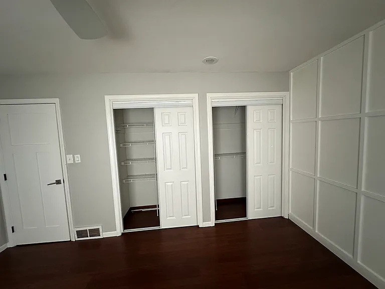 master bedroom with finished accent wall and closet space