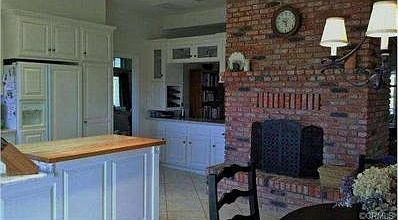 Double-sided brick fireplace and dry bar between kitchen and liv