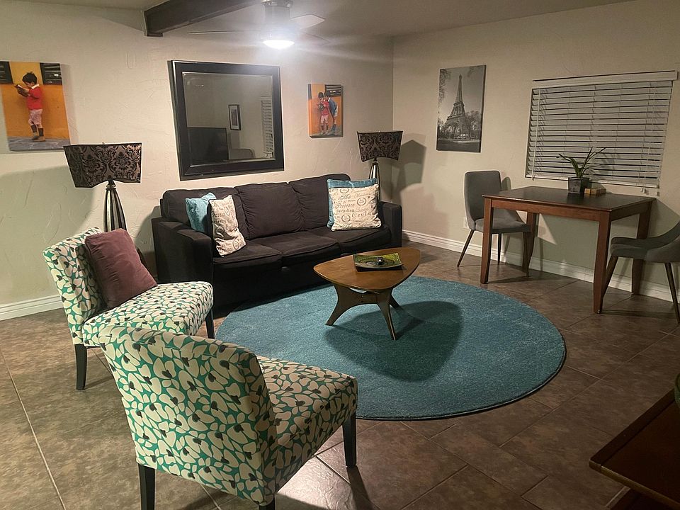 Living room with sofa bed, bistro set and additional seating.