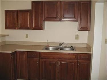 Kitchen has wood cabinets, 
