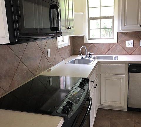 Kitchen with corner sink & two windows viewing back yard
