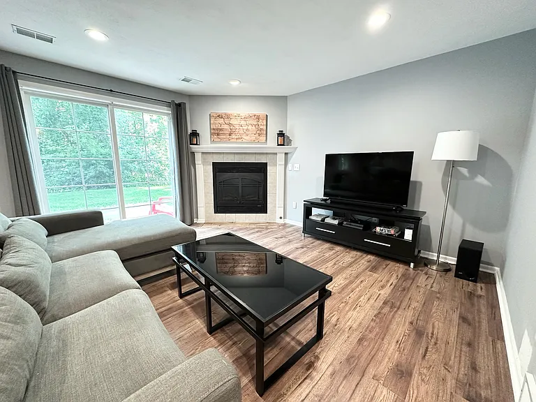 Basement living area with gas fireplace and walkout basement sliding doors