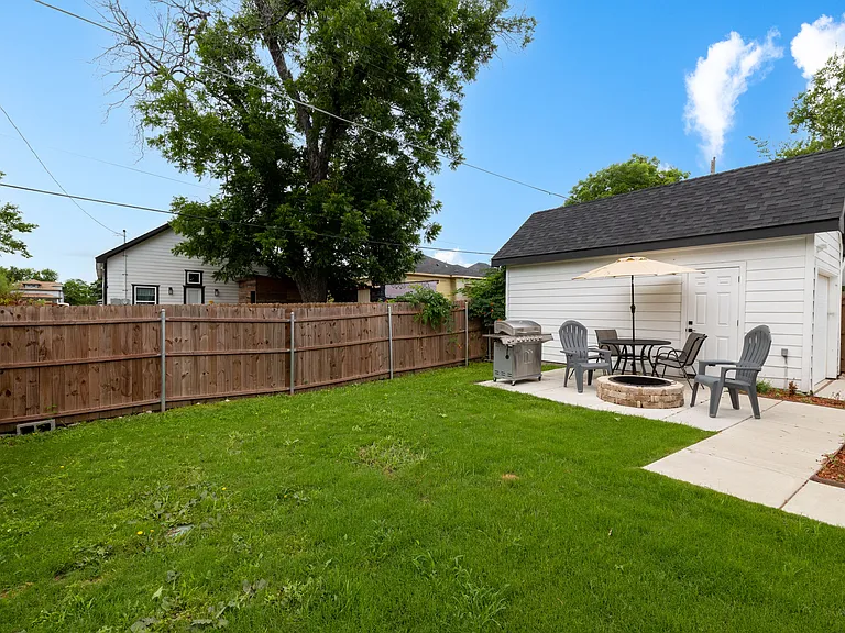 Spacious, fully-fenced backyard with fire pit and seating.