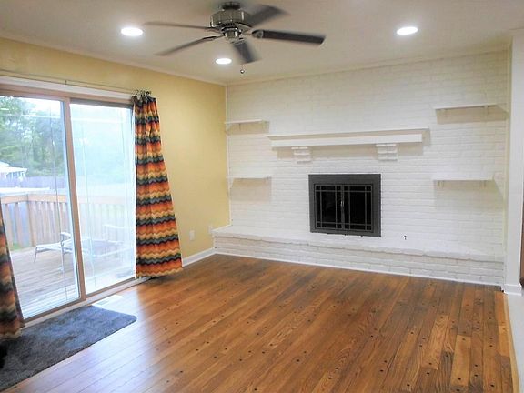 Family room with wood floors, brick fireplace and walk out to the deck!