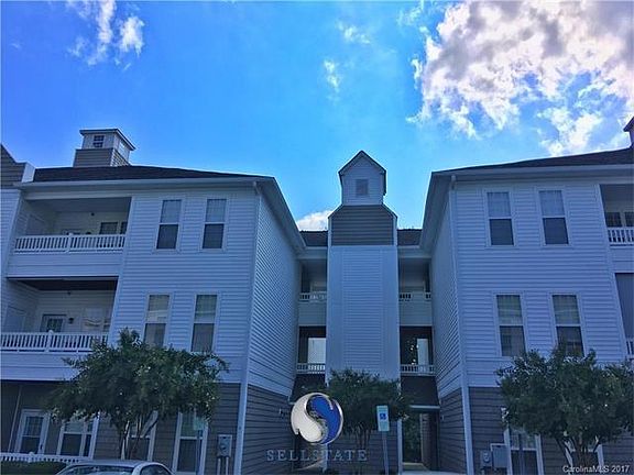 Front side; 3rd floor unit and porch overlook the wooded area behind the home