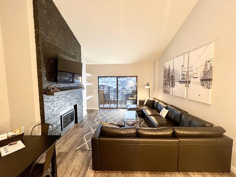 Living room with large sofa-bed sectional and storage chaise lounge, 65 in LED TV, fireplace, balcony with grill and sweeping views of Beaver Creek mountain