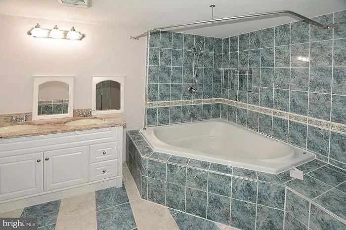 Downstairs hallway upgraded bathroom with jacuzzi style sunken tub.