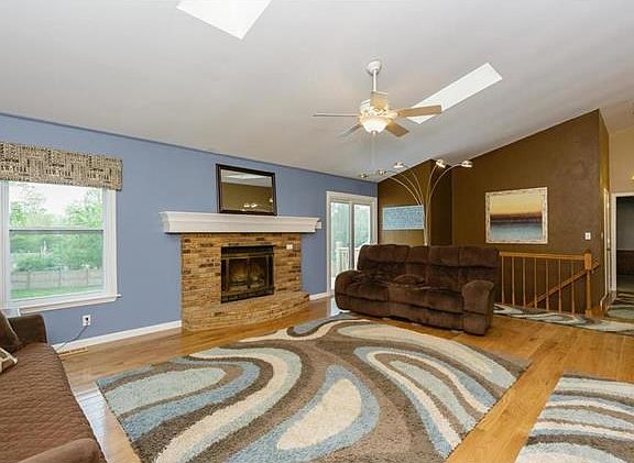 Spacious Family Room with woodburning fireplace, newer 5" hardwood floors, vaulted ceiling, skylight