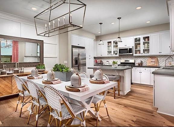 Bright, well-equipped kitchen with quartz counter tops and subway tiles.