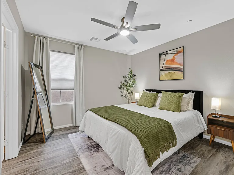 Bedroom 1 with Queen size bed, walk-in closet, ceiling fan, and black out curtains